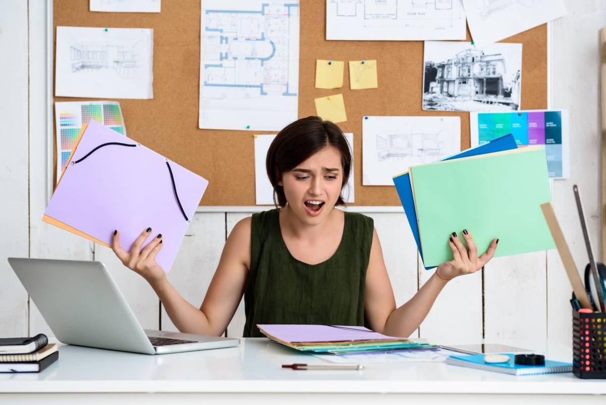 Recruiter looking frustrated while reviewing resumes due to hiring problems